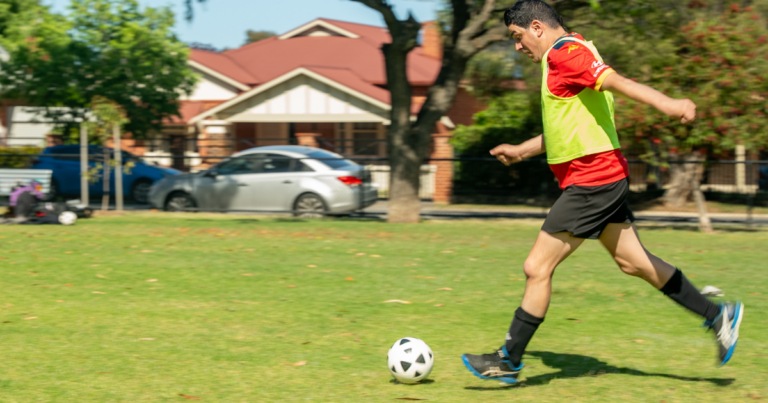 United Abilities client playing soccer during an NDIS group activity.